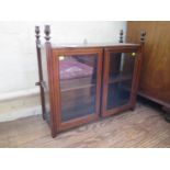 An Edwardian mahogany and boxwood hanging display cabinet, with flame finials over a pair of
