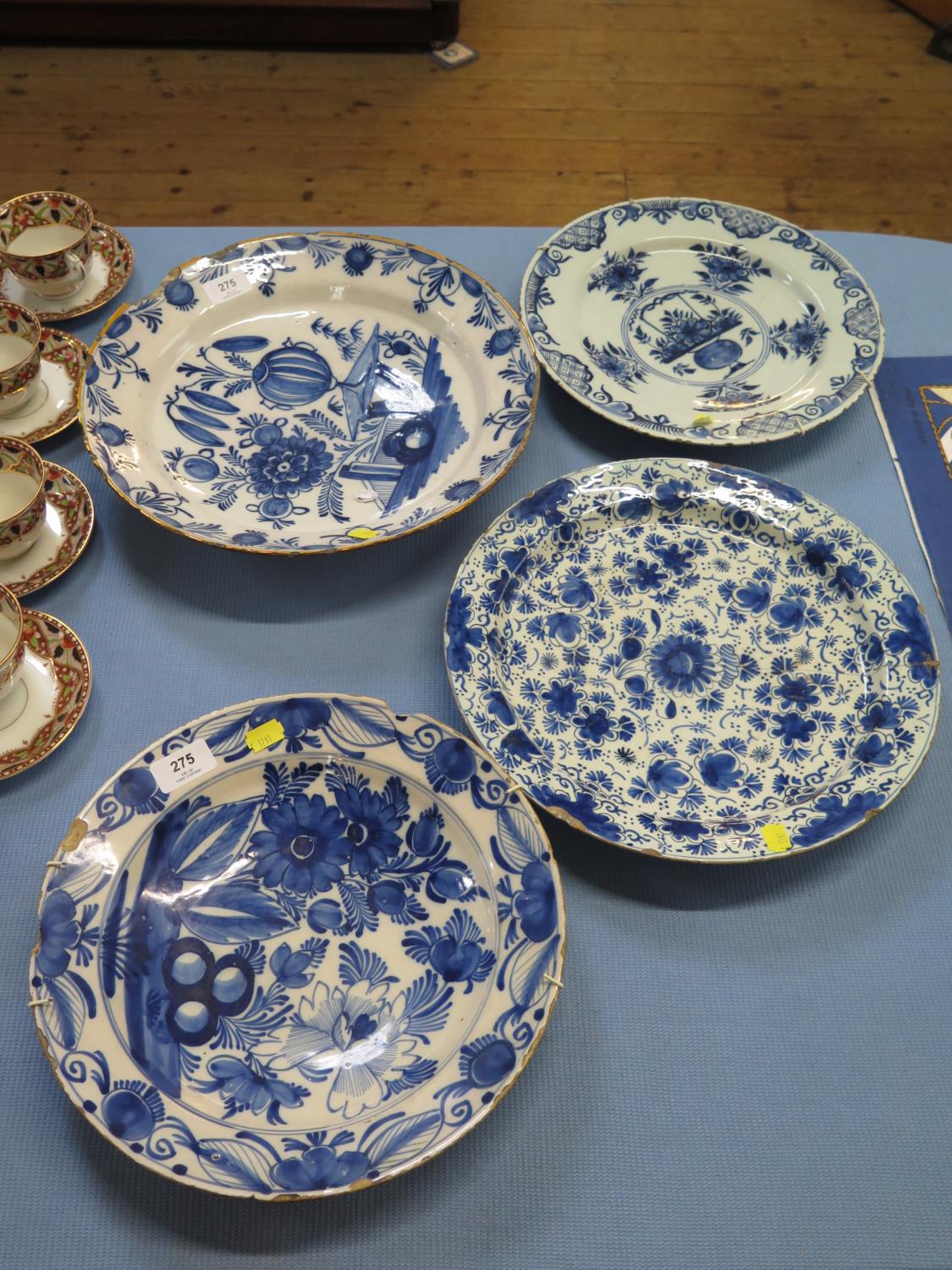 Four blue and white tin glazed chargers, with floral designs, largest 35.5 cm diameter, as found (4)