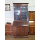 A mahogany bureau bookcase, the moulded cornice over a pair of glazed doors enclosing adjustable