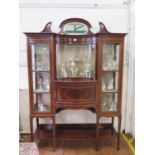 An Edwardian inlaid mahogany display cabinet, the raised oval mirrored back over a concave glazed