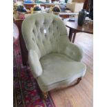 A late Victorian walnut button back armchair, with turned tapering legs and pot castors