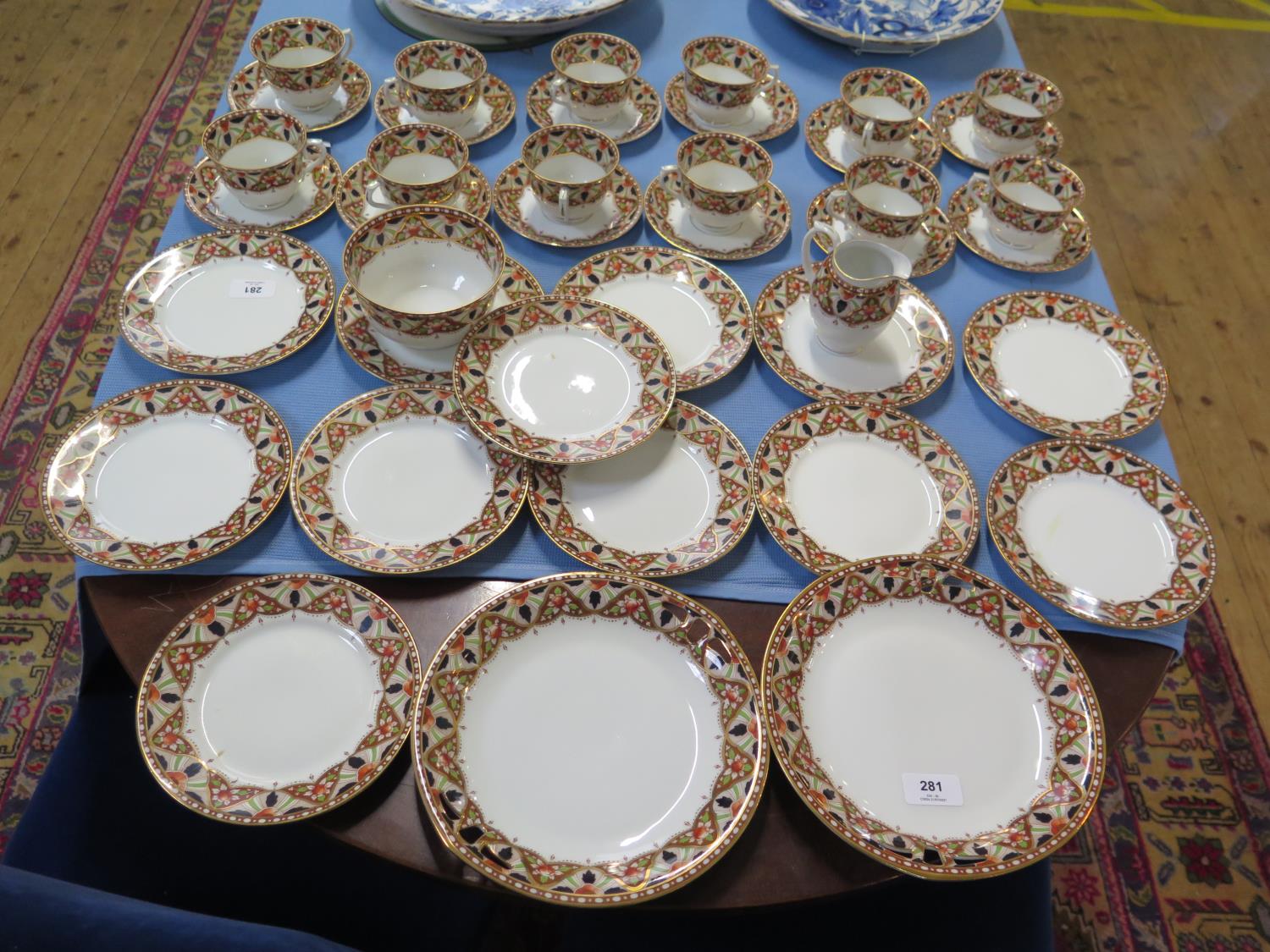 An early 20th century part breakfast service with red and blue gilt borders, including twelve side