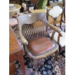 A 1930s spindle backed office chair, on cabriole legs with pad feet and stretchers