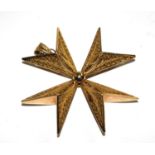 A gold Maltese cross with lattice work decoration
