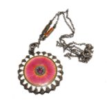 A 1920s locket and chain, the locket set with pink and white enamel with a red stone to the middle