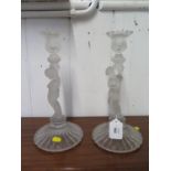 A pair of glass candlesticks, in the form of putti holding torches, on circular bases, 31 cm high