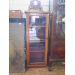 A Victorian walnut display cabinet, the glazed door enclosing adjustable shelves on a later plinth