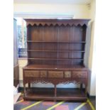 A George III style stained oak dresser and rack, the stepped rack over a base with five frieze