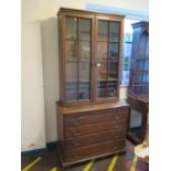 A George III oak chest of drawers, with associated bookcase, the bookcase with glazed doors and