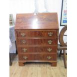 A reproduction mahogany bureau, the sloping fall over four graduated drawers on bracket feet, 70