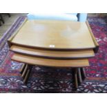 A nest of three teak occasional tables, with bowed tops on T-shape trestle bases, largest 74 cm x 55