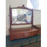 An early 19th century mahogany boxwood strung toilet mirror, with reeded supports over a bowed front