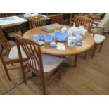 A teak extending dining table and six dining chairs, including two carvers, with shaped rail backs