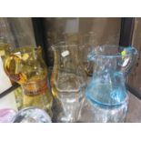 Three 1970s hand blown jugs, in blue, amber, and brown, 17 cm high (3)