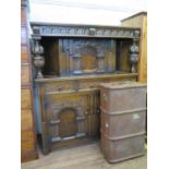 An inlaid oak court cupboard, with arched panel doors, three frieze drawers and cup and cover