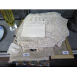 A 19th century lace table cloth, a child's lace bonnet, other textiles and a framed sampler