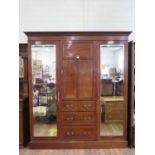 An Edwardian chevron banded mahogany compactum wardrobe, the central panelled door enclosing a shelf