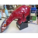 A PM Sevres red glazed figure of a polar bear on a rectangular base, 33cm high (chip to the shoulder