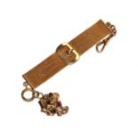 A gold colour metal Milanese watch fob attached to a rough piece of gold colour metal