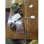 An American three piece cane fishing rod, a two piece cane fishing rod, a brass reel 5cm diameter, a