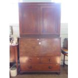 An early 19th century mahogany secretaire cabinet, the pair of panelled doors enclosing adjustable