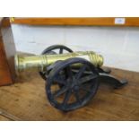 A miniature brass cannon on a metal carriage, 34cm long
