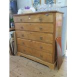 A late Victorian oak chest of drawers, the top drawer with fall front enclosing four trays, over