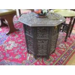 An Indian profusely carved octagonal table, the top decorated with vine leaves and grapes, on fret