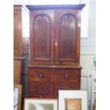 A mid Victorian mahogany secretaire cabinet, the arched panelled crossbanded doors enclosing shelves