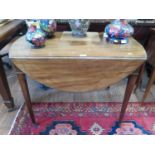 A George III mahogany Pembroke table, the oval top over a frieze drawer on square tapering legs