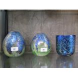 A pair of Siddy Langley Art Glass vases, with blue lustre floral design on a bottle green ground,