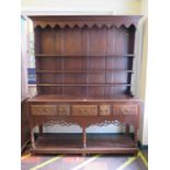 A George III style stained oak dresser and rack, the stepped rack over a base with five frieze