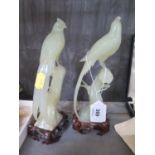 A pair of carved jade figures of exotic birds, on timber stands, 20 cm high, damaged (2)
