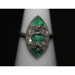 A platinum art deco style marquise shaped ring set with emeralds and diamonds. Emeralds approx 0.
