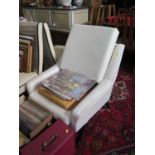 A 1950s cream faux leather armchair, the reclined button back on ebonised square moulded legs