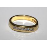 An 18 carat yellow gold ring set with seven round diamonds. Size J