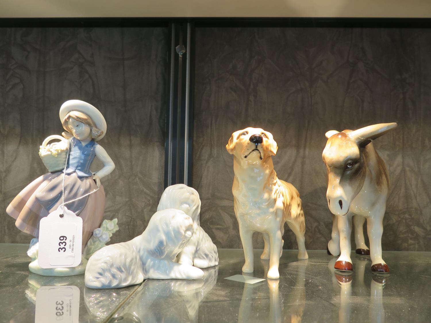 A Lladro figure of a girl with a basket of flowers, a Beswick figure of a Labrador, and two other