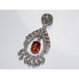 An 18 carat white gold diamond set pendant with a central articulated drop set with a fire opal