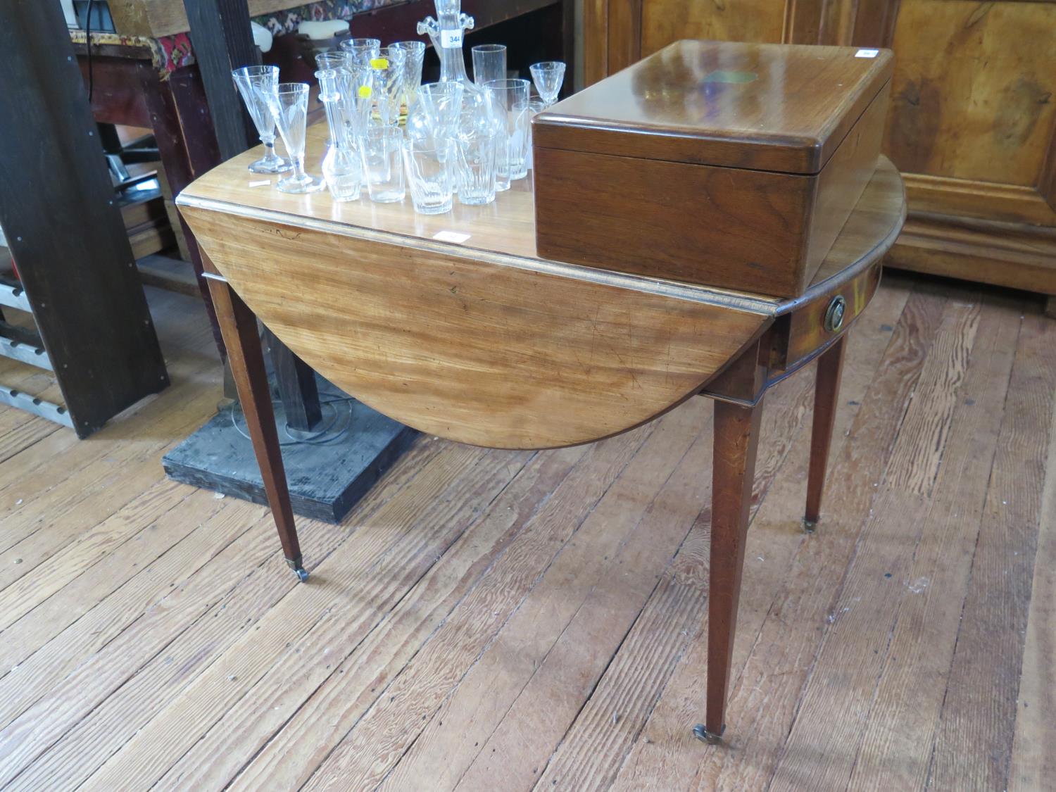 A George III mahogany Pembroke table, the oval top over a frieze drawer on square tapering legs