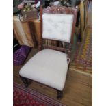 An Edwardian walnut lady's fire side chair, with carved top rail, button back and ring turned