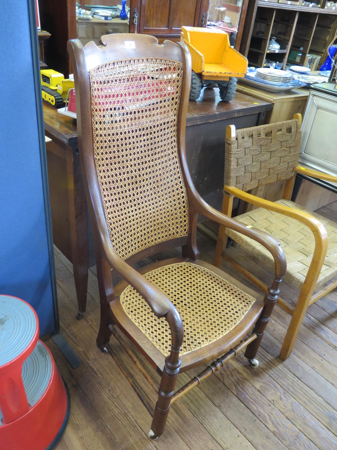 A Victorian elm and cane high back armchair, with ring turned legs joined by stretchers, on later