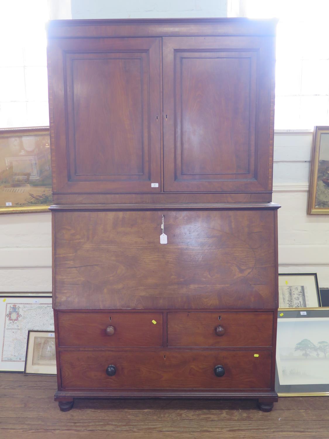 An early 19th century mahogany secretaire cabinet, the pair of panelled doors enclosing adjustable