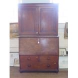 An early 19th century mahogany secretaire cabinet, the pair of panelled doors enclosing adjustable