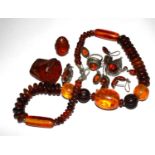 A collection of amber jewellery including four pairs of earrings, two rings, a beaded necklace, a