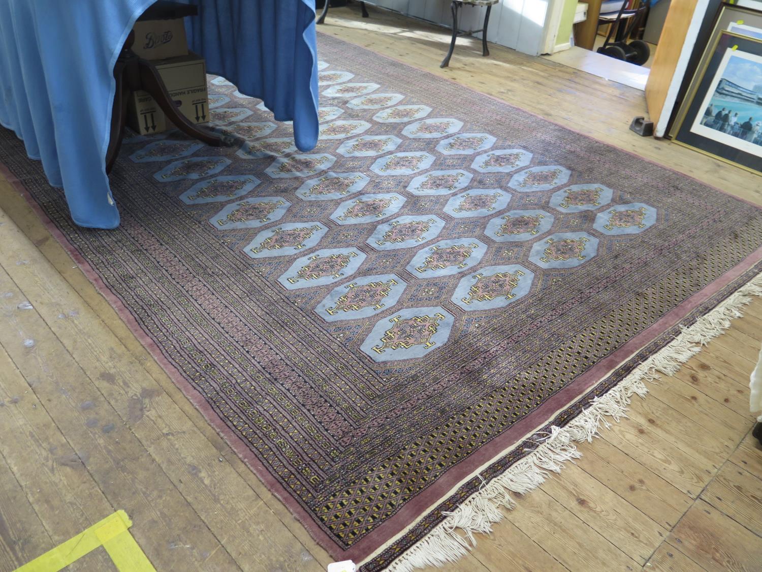 An Afghan blue ground carpet, with four rows of medallions within a multiple border, 333 x 226 cm