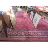 A Belgian Afghan design carpet, the red ground with an all-over bow design within a multiple border,