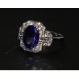 An oval intense deep purple AAA tanzanite and diamond cluster dress ring set in 18ct white gold. T