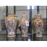 A pair of famille rose vases and covers, painted with panels of figures and birds, unmarked, 24 cm