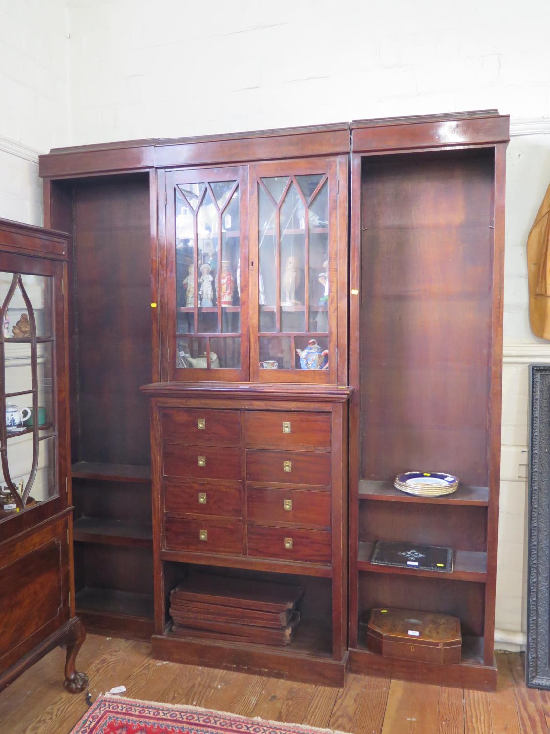 A mahogany breakfront bookcase cabinet, the moulded cornice over a pair of glazed doors above