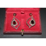 A Pair of 14ct gold and silver drop earrings set with garnet and diamonds. Boxed